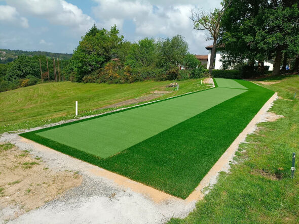 Asheville Outdoor tee line consisting of one continuous green synthetic grass strip surrounded by trees